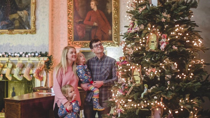A young family enjoying the Christmas decorations in the house.